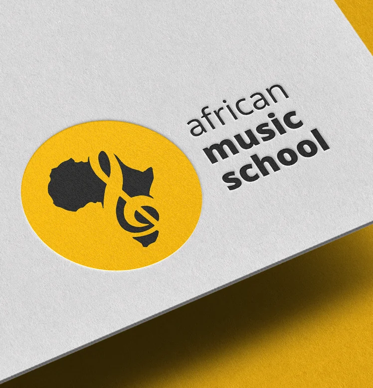 Logo African Music School – kontur Afryki i klucz wiolinowy w żółtym kole, wytłoczone na papierze